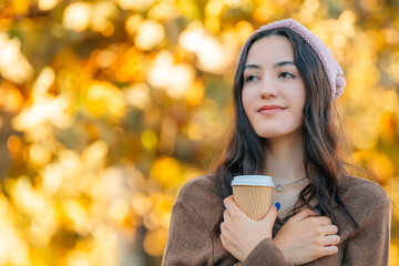 girl or young woman with cup of coffee in autumn or winter outdoors