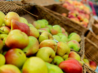 Freshly picked pears in a wicker basket for sale in the market and supermarket. Fresh tasty, sweet fruits in a basket for sale in the mall. Close-up