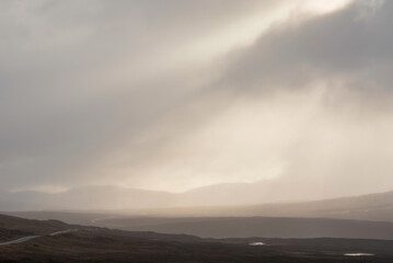 Naklejka na ściany i meble Beautiful Winter landscape image of view along Rannoch Moor during heavy rainfall giving misty look to the scene