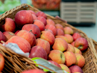Apples in a wicker box on a grocery shelf. Close-up of fruit in a supermarket. Fresh red apples on the market counter. Healthy eating and vegetarianism