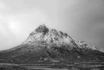 Black and white Majestic dramatic landscape Winter image of iconic Stob Dearg Buachaille Etive Mor mountain in Scottish Highlands