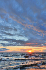 dark sky with sunset clouds above sea with waves