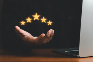 Customer satisfaction assessment, Good service experience. Best Rated 5 Stars for review. evaluation survey research concept. Man holding stars with computer laptop on desk. feedback online - obrazy, fototapety, plakaty