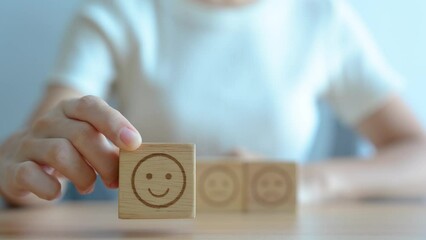 Hand choosing smile face from Emotion block.  customer review, good experience, positive feedback, satisfaction, survey, rating service, assessment, mood, world mental health day concept