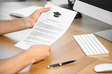 Fototapeta premium Student with acceptance letter from university at wooden table indoors, closeup