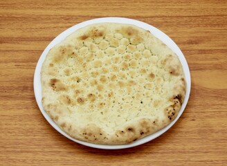 plain naan or sada nan, nun, roti, tandoori, chapati, pita, bread served in a dish isolated on wooden table side view of indian, pakistani food