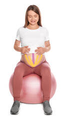 Sporty pregnant woman with kinesio tapes doing exercises on fitball against white background