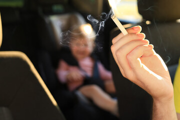 Mother with cigarette and child in car, closeup. Don't smoke near kids
