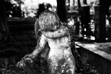 Beautiful statue of angel at cemetery. Monochrome photography