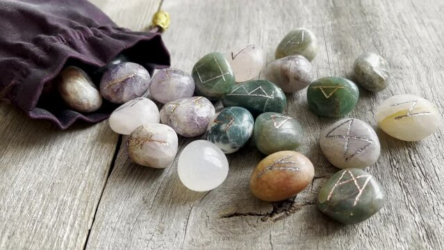 Set of Runes engraved on colorful natural gem stones. Scattered rune stones prepared for magical ritual