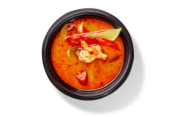 Bowl of Thai soup tom yam with chicken, red chili pepper and lemon