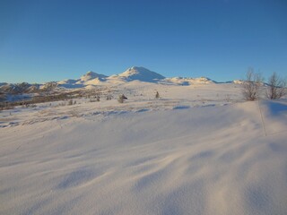 Beautiful view of a snow covered landscape in Tuddal, Norway, with Gaustatoppen in the background