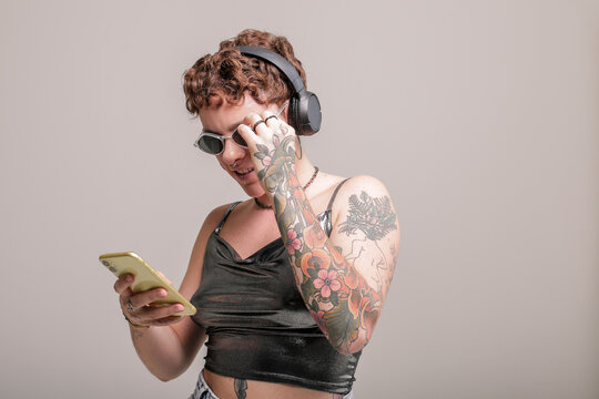 Portrait of a girl in front of a background, holding a phone, listening to music