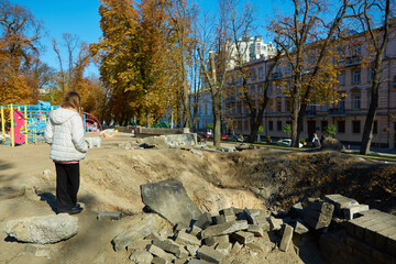 Kyiv, Ukraine - October 16, 2022: People near the funnel from the explosion of a Russian rocket on a children's playground in the center of the capital.