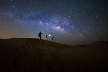 Photographer Camping in the sand dune desert with milky way star of Abu Dhabi, UAE.