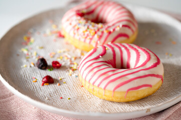 Close-up Aufnahme von zwei Frosted Donuts in Weiss-Pink