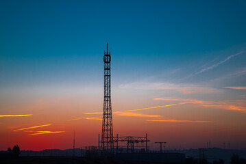 relay Cell tower in the early morning against the background of an orange sky