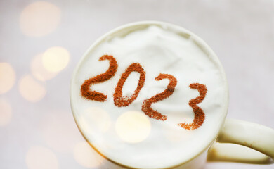 2023 on coffee foam. Festive glowing. New Year planning