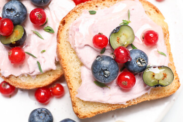 Tasty sandwiches with cream cheese, blueberries and red currants, closeup