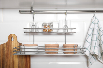 Kitchen towel hanging on hook rod and shelves with ramekins indoors