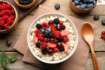 Flat lay composition with tasty oatmeal porridge and ingredients served on wooden table. Healthy meal