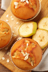 Tasty muffins served with banana on wooden board, top view