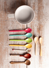 Plastic teaspoons with cup on wooden table