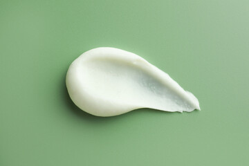 Sample of face scrub on green background, top view