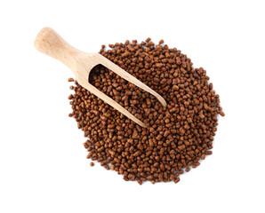 Wooden scoop with buckwheat tea granules on white background, top view