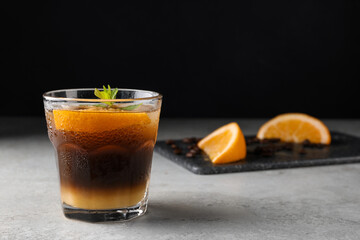Tasty refreshing drink with coffee and orange juice on grey table, space for text
