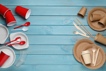 Flat lay composition with plastic and eco disposable tableware on light blue wooden background....