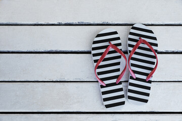 Stylish flip flops on white wooden table, flat lay. Space for text