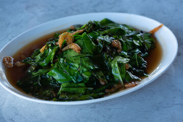 Stir-fried malindjo leaves with dried shrimp on the table.