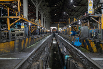Fototapeta premium Engineer checking train engine Prepare for repainting for use in train stations. Engineers wear protective clothing and helmets to work safely as standard. 