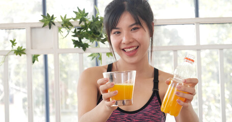 Women hands holding cold orange juice fresh fruit cool drinking. Asian women smile laugh look at camera health care home fitness lifestyle. Beautiful female pouring orange juice from cocktail bottle