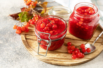 Fresh ripe viburnum berry with sugar for preparation vitamin and antioxidant tea on a stone table. Source of natural vitamins. Used in folk medicine. Copy space.