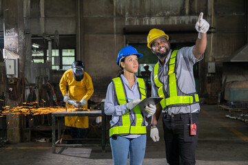 Engineers in a steel mill with a welder to grind steel to assemble Consult the size of the steel workpiece. Bring the workpiece to assemble the locomotive.