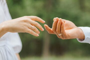 Two hands with wedding rings reaching out to each other