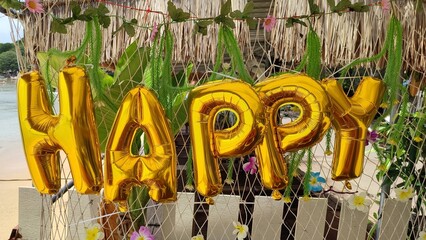 Fototapeta premium Yellow color inflatable helium balloons forming word happy