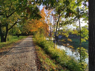 park alley in spring, by the river, beautiful colors of leaves