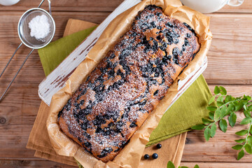 Fresh blueberry loaf of bread muffin cake on wooden table. Horizontal, top view from above