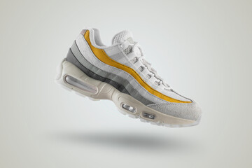 Light gray sneaker with yellow accents on a white isolated background, men's fashion, sport shoe, ...