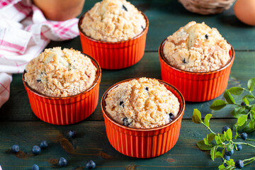 Blueberry muffins with powdered sugar and fresh berries on the green table.
