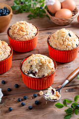 Homemade blueberry muffins made with organic ingredients on rustic table.
