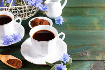 Composition of chicory drink, chicory powder and spoon on a table. Healthy chicory beverage. Copy space, view from above.