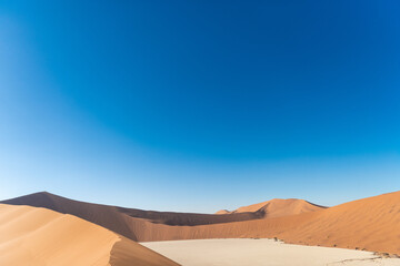 Fototapeta na wymiar Photo of the blue sky with a duna in desert, Namibia. The concept of exotic, extreme and photo tourism.