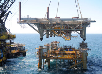 workers are transported to the topside section of an offshore platform lowered onto the jacket...