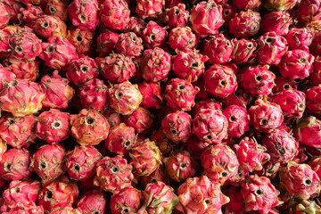 pile of fresh dragon fruit for sale, soft focus