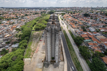 Abandoned buildings in the city of Campinas, countryside of São Paulo. Vegetation, construction debris and vehicles circulating around the residential neighborhood.