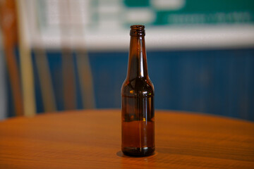 Opened beer bottle on a wooden table. Copy space, mock up.
